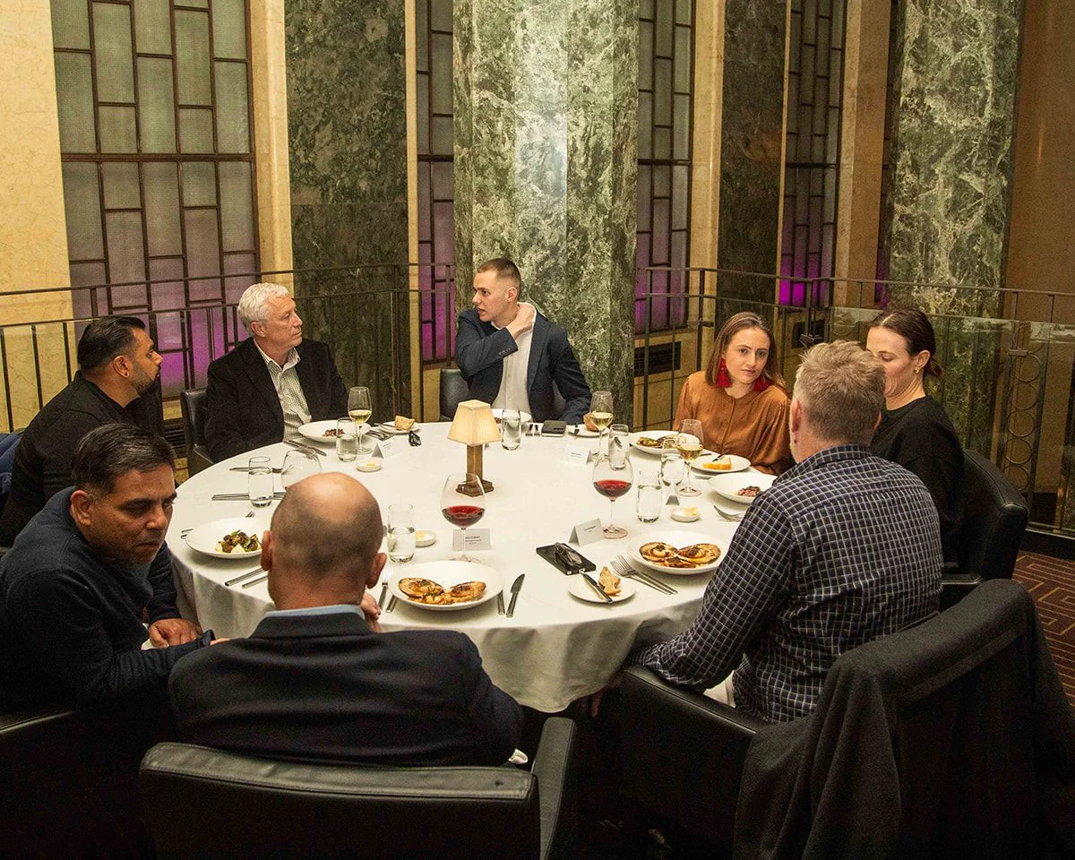 Banking and financial services leaders in conversation around a round dinner table