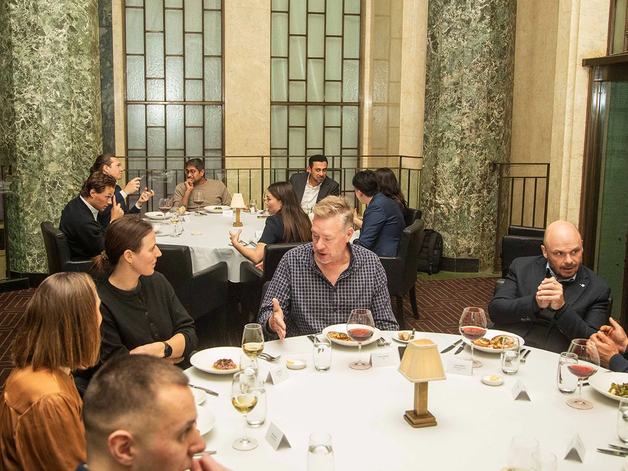 Banking and financial services guests in conversation around a round dinner table