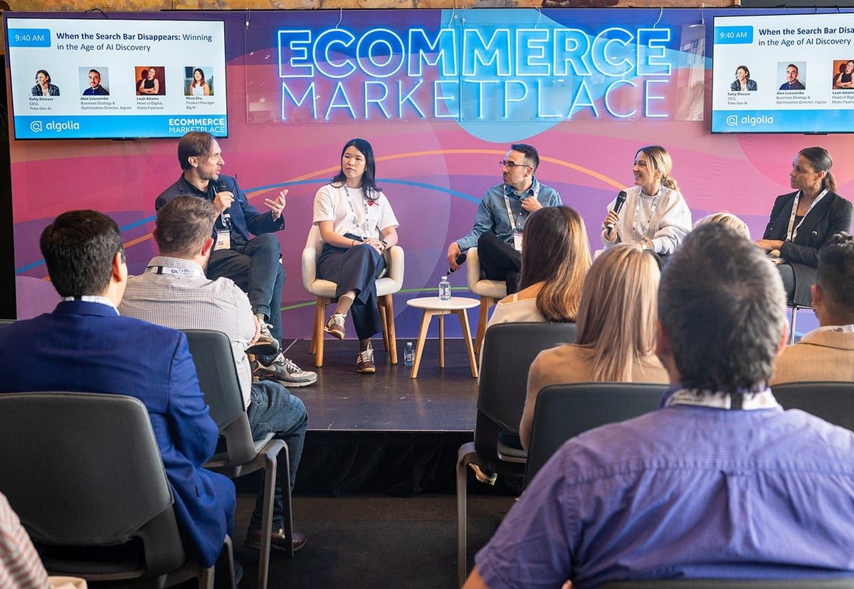 A panel seated on the Ecommerce Marketplace stage, with the session screen above and the audience in front