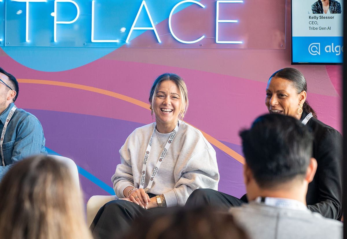 A smiling panellist on the Ecommerce Marketplace stage, seen past an audience member