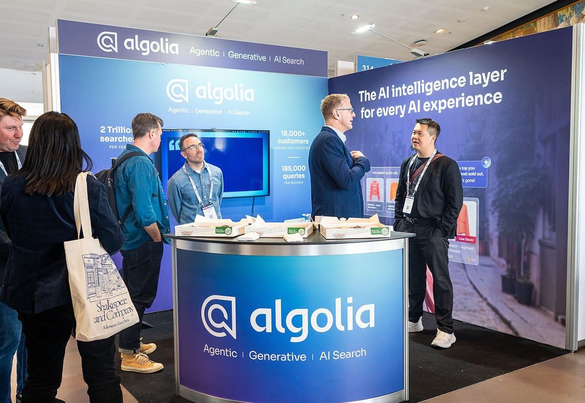 Visitors talking with the team at the Algolia stand