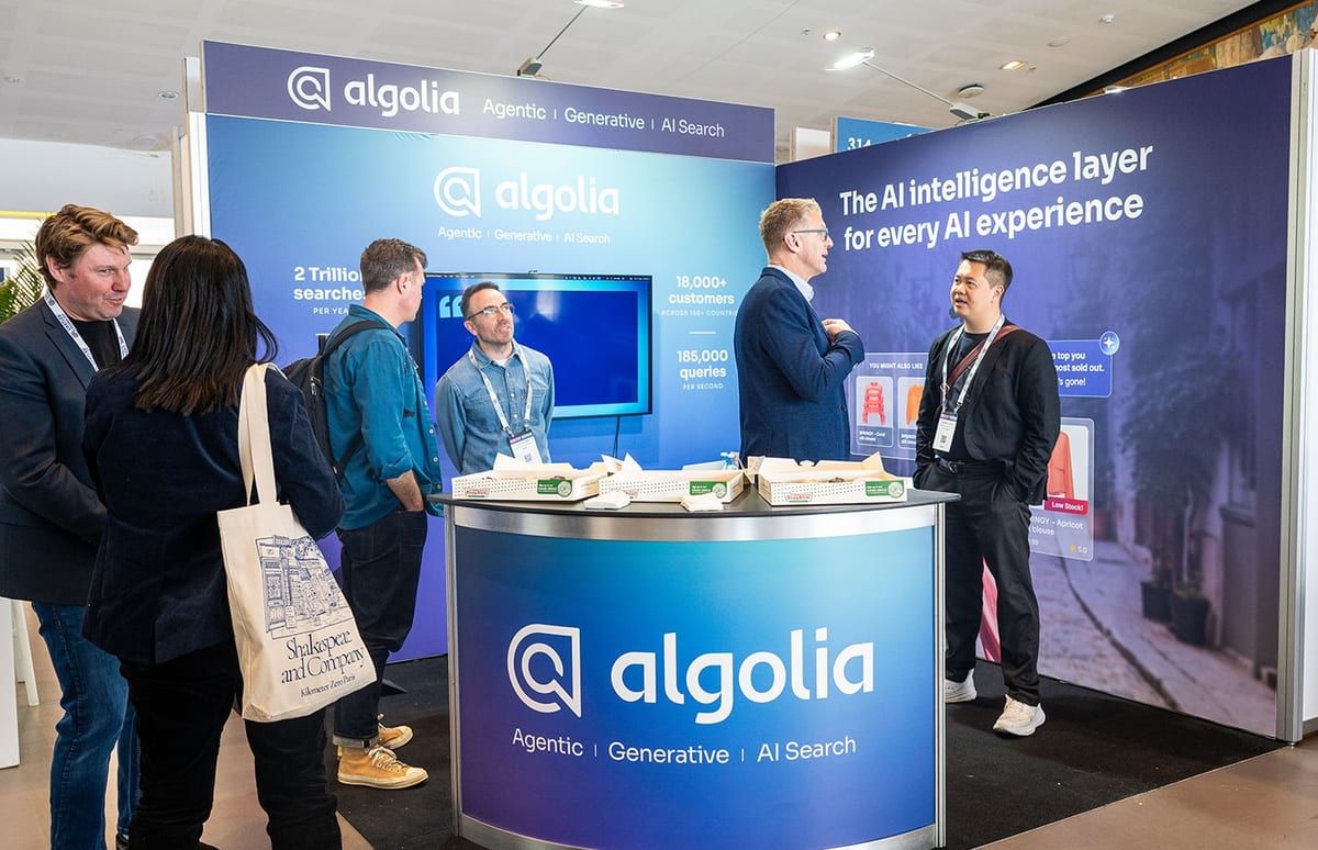 Visitors talking with the team at the Algolia stand