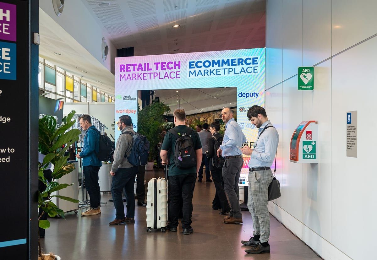 Attendees arriving under the Retail Tech and Ecommerce Marketplace entrance arch