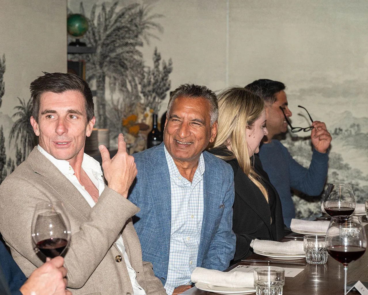 Dinner guests laughing and talking across the table at The Gidley