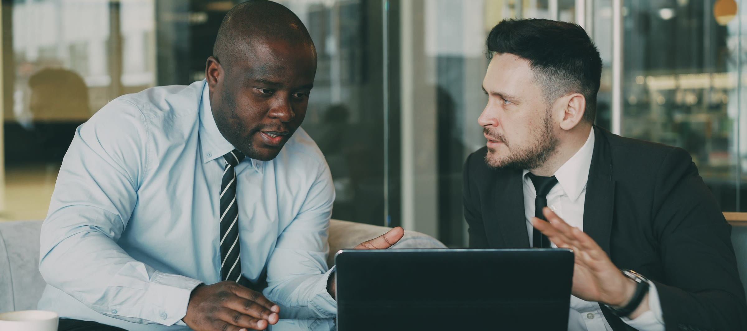 A technology provider in a 1-to-1 meeting with a retailer at a meeting table