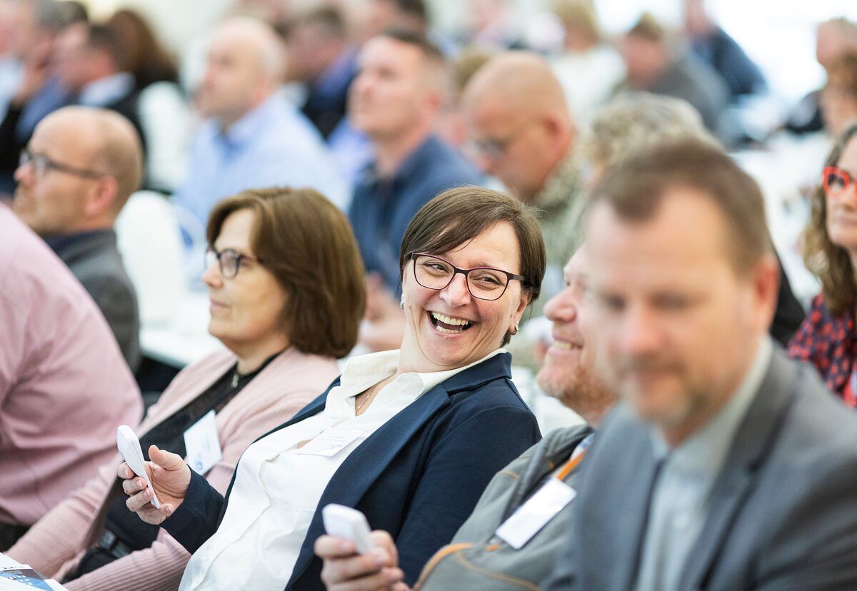 A seated conference audience watching a presentation