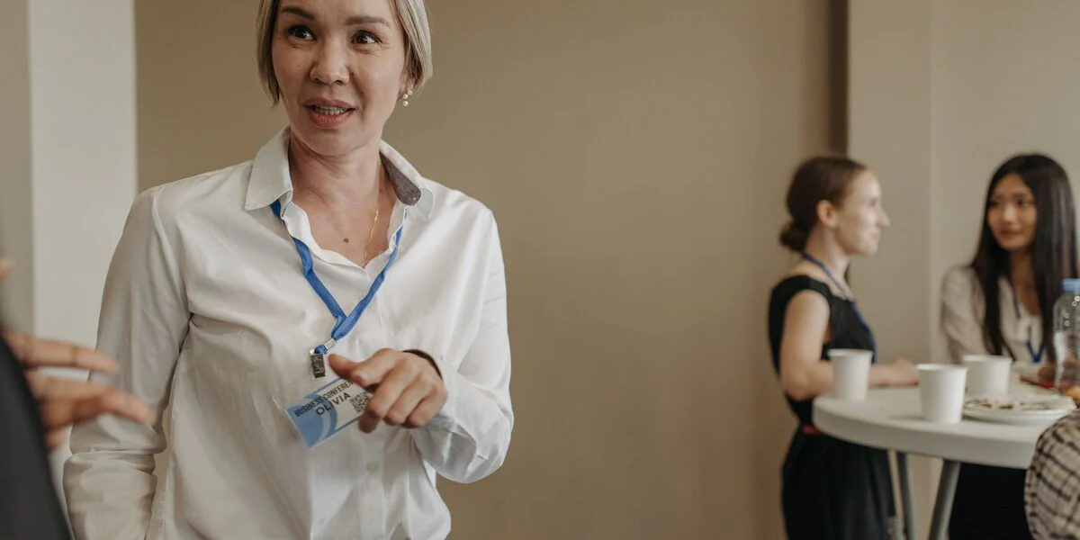 A delegate wearing a conference lanyard chatting at a networking function