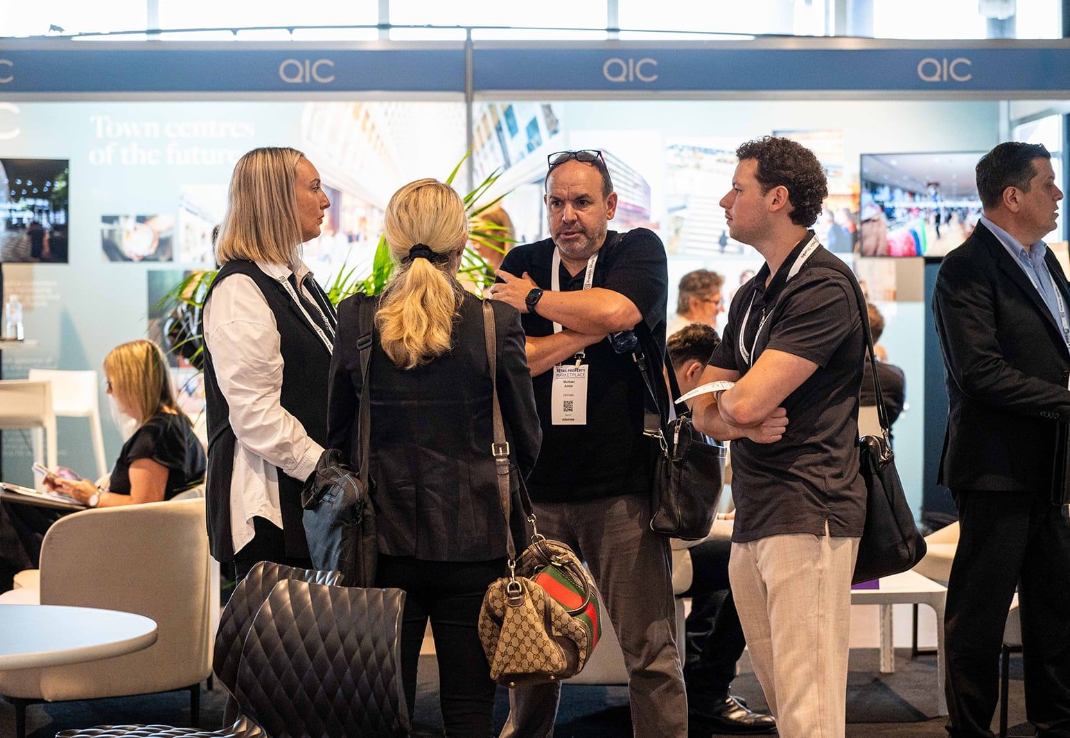 A group of visitors talking in front of a property investment stand