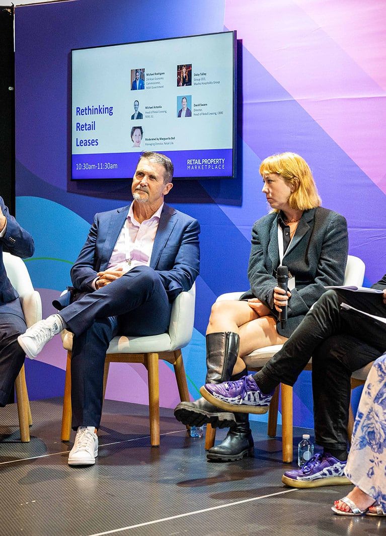 A panellist speaking into a microphone during a session on retail leases