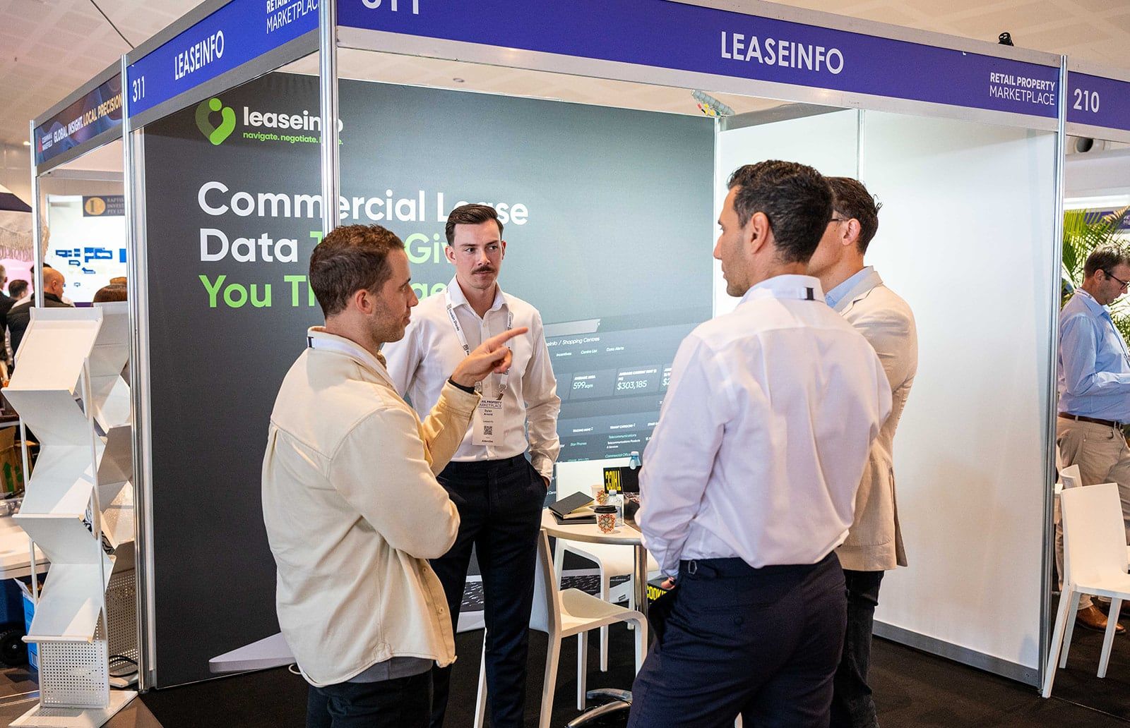 Exhibitors explaining a lease data product to visitors at their stand