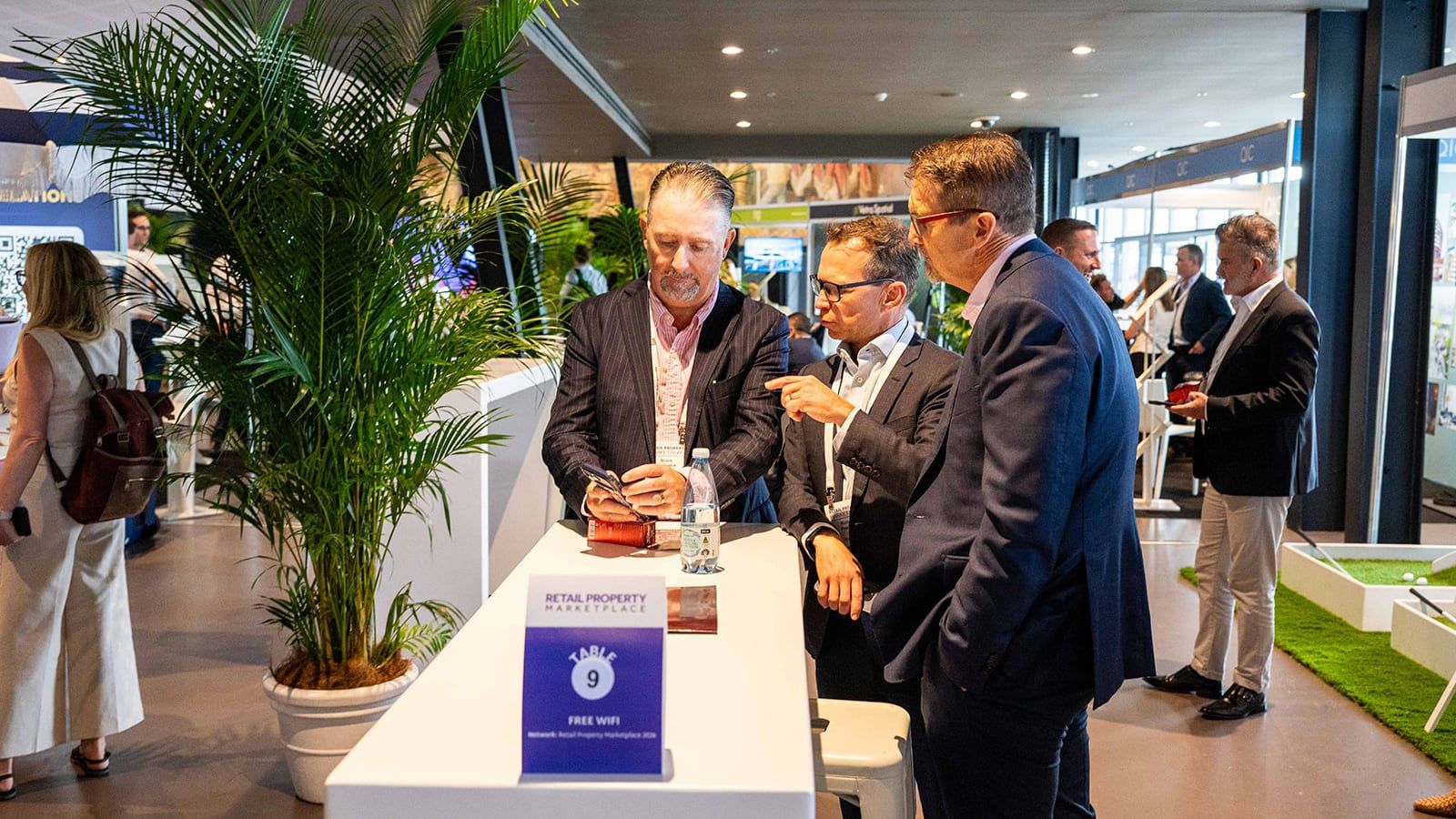 Delegates talking at a numbered meeting table on the exhibition floor