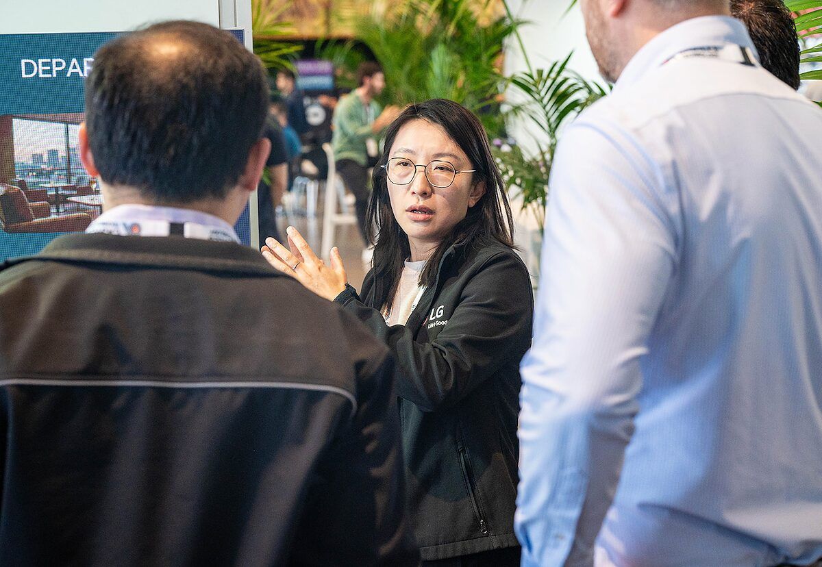 An exhibitor explaining something to visitors in a close conversation at her stand