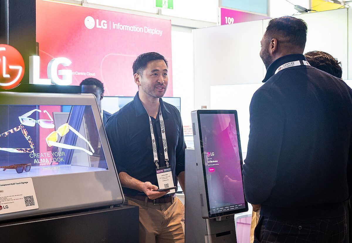 An exhibitor showing visitors an interactive display screen at the LG stand
