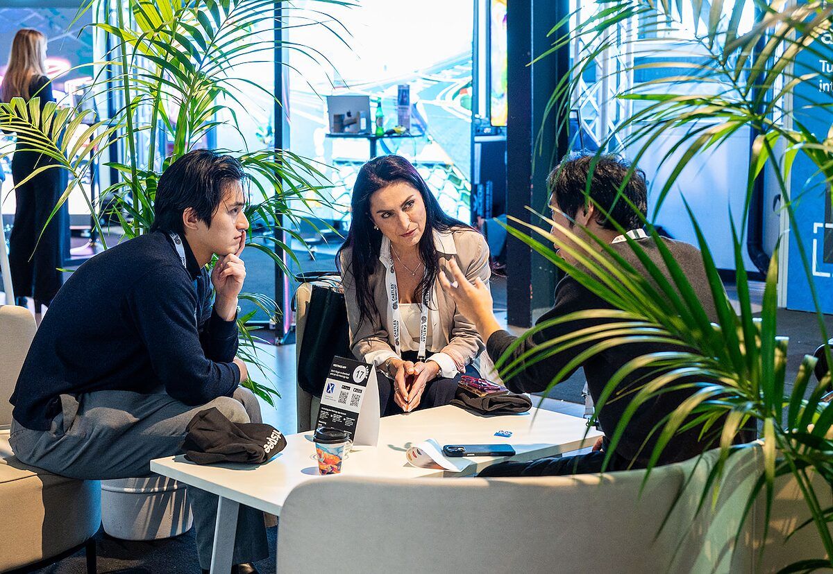 Two attendees in a one-to-one meeting at a table among palms