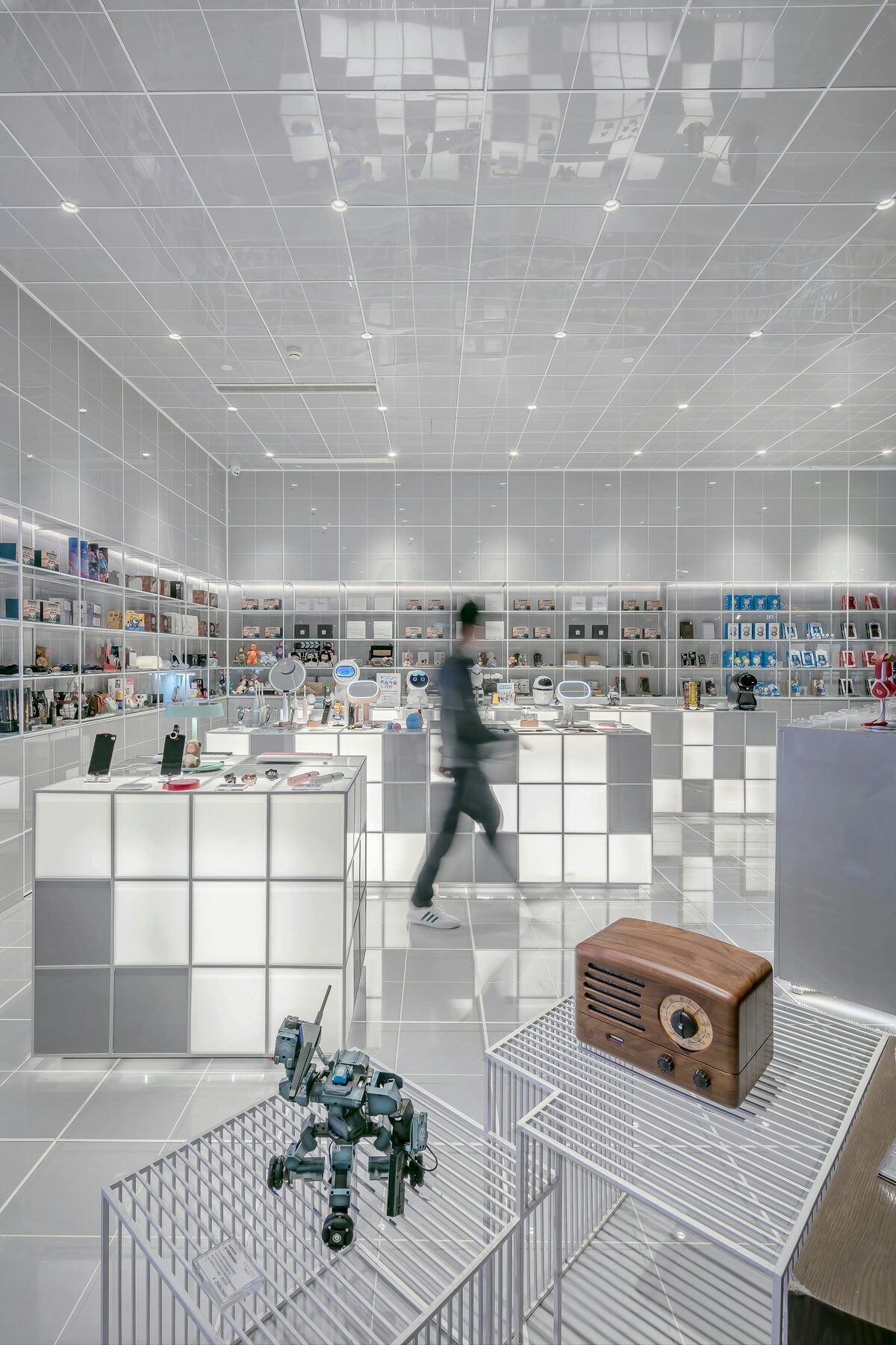 A bright modern store with illuminated display cubes and a small robot on show