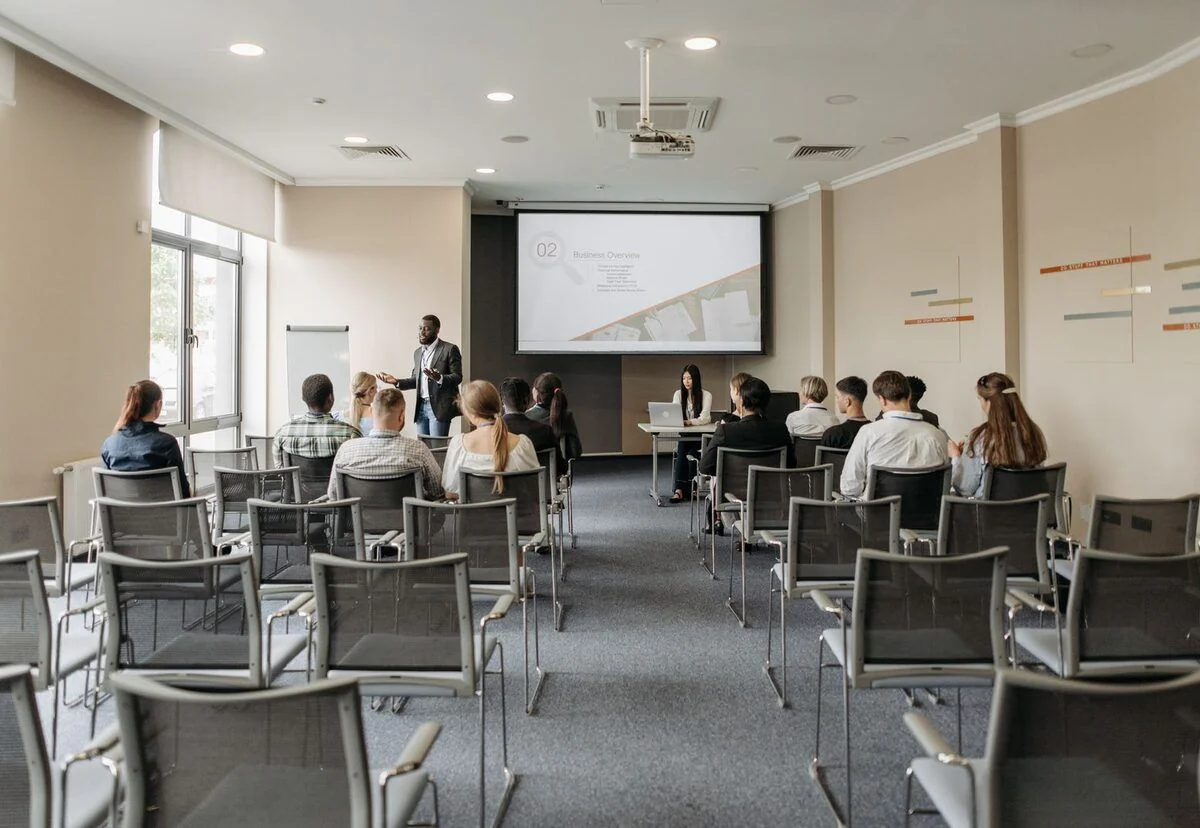A seminar room with a seated audience and a projector